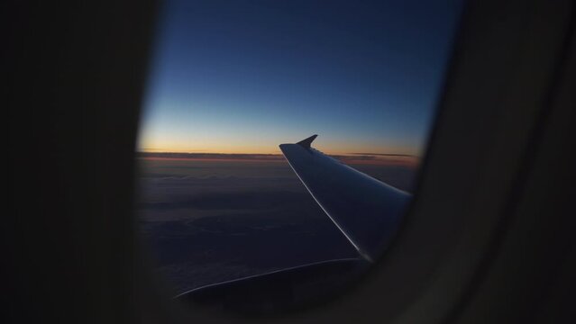 Plane window view at horizon during sunset