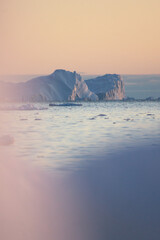 portrait mode icebergs in north greenland polar region in sunset pastel colour mood iceberg in sunrise © Salvisberg