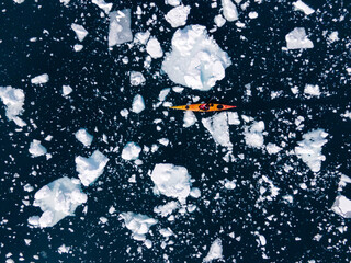 kayak next to a gigantic iceberg in ilulissat greenland outdoor sports kayaking along frozen icebergs in open sea water