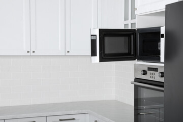 Fototapeta premium Modern oven and microwave in white clean kitchen