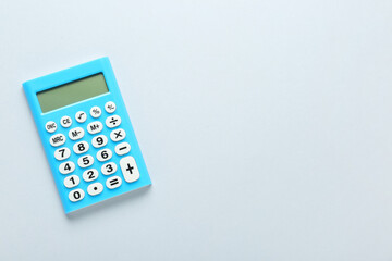Light blue calculator on light background, top view. Space for text