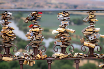 Love padlocks on the bars of a viewpoint in Toledo, Spain - obrazy, fototapety, plakaty