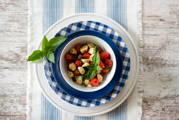 Top view of a bowl of fresh tomato mozzarella salad garnished with basil