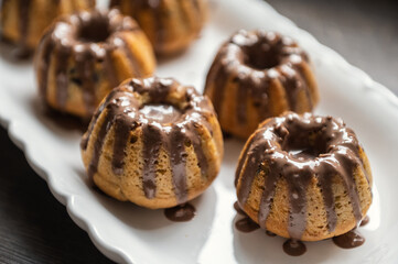 Coating with chocolate glaze muffins at birthday party