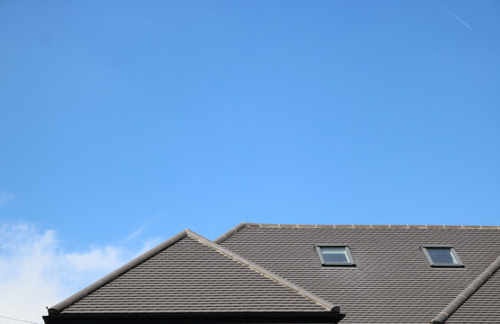 Contemporary grey roof with skylights against deep blue sky with copy space