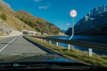 Car moving fast with speed limit violation on a twisty road with a rocky landscape. View from the...