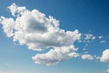 Naklejka na ściany i meble white fluffy cumulus clouds against summer blue sky