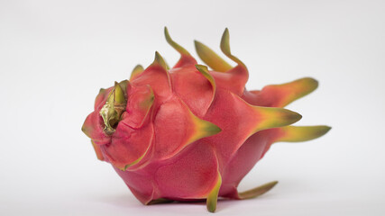 PITAHAYA OR DRAGON FRUIT WITH RED SKIN AND WHITE PULP ON A WHITE BACKGROUND