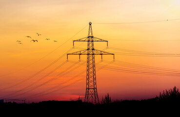 High voltage electricity pylons and transmission power lines on the blue sky background.