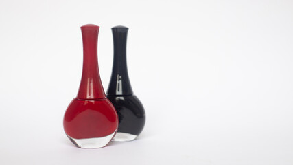 JARS OF RED AND BLACK NAIL PAINT ON A WHITE BACKGROUND WITH COPY SPACE