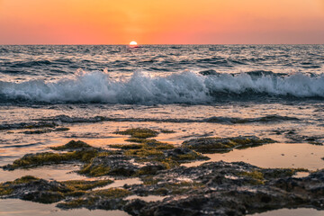 sunset at the beach with waves and colour high quality