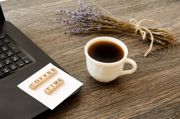 a cup of coffee near the computer and a bouquet of lavender, the inscription coffee time