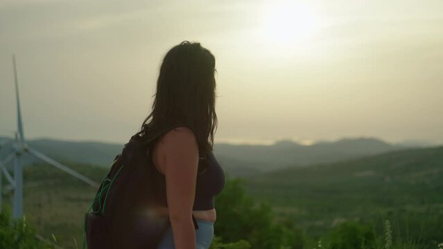 Slow motion video of a girl on a hiking trail in the mountains. Beautiful landscape of mountain peaks and woman with backpack on hiking.