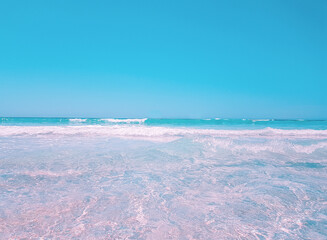 Background beach with sea wave. Texture sand. Gentle pastel colors. Vintage filter. Blue sky and azure coast, Es Trenc, Mallorca. Relax atmosphere.