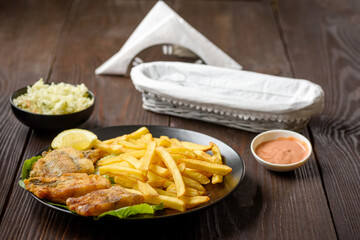 fish and chips on a black plate
