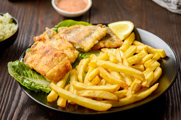 fish and chips on a black plate