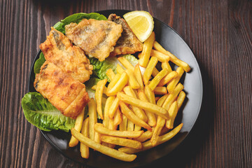 fish and chips on a black plate