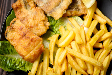 fish and chips on a black plate