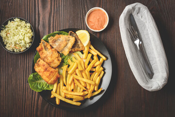 fish and chips on a black plate
