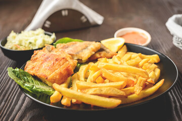 fish and chips on a black plate
