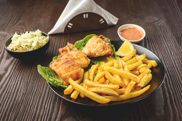 fish and chips on a black plate
