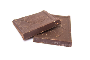 two cubes of dark chocolate lie on a white background