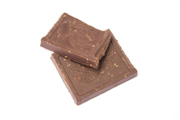 two cubes of dark chocolate lie on a white background