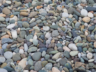 Large beach pebble. Background of small stones. Gray background from stones. Pattern.