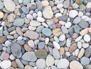 Large beach pebble. Background of small stones. Gray background from stones. Pattern.