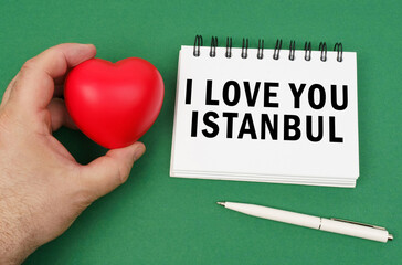 On the green surface are a pen, a notepad with the inscription - I love you Istanbul.