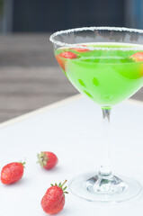 Colorful bright green cocktail cactus with strawberries, delicious refreshing