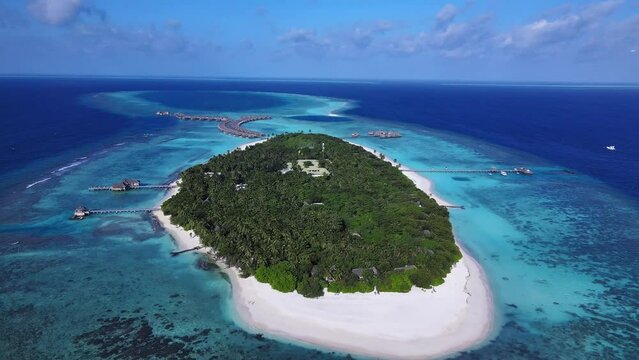 Tropical atoll island in Maldives with coral reef and turquoise sea water. Touristic vacation holidays travel destination. Scenic seascape. Drone aerial video footage. Vakkaru, Maldives..