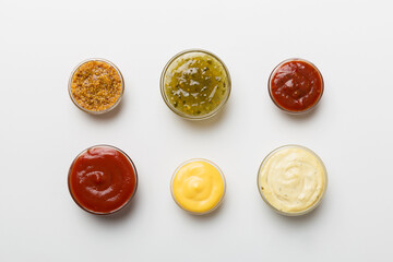Different types of sauces in bowls on a colored Board . Top view. various sauces copy space