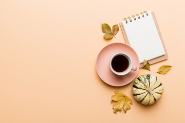 Autumn composition: fallen leaves and notebook mock up on colored background. Top view. Flat lay with copy space
