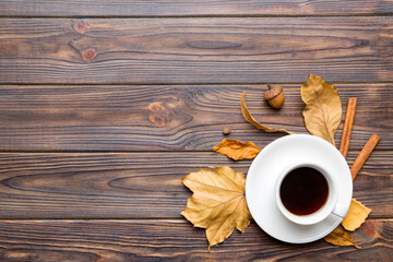 Flat lay composition with colorful Autumn cup of coffee and leaves on a color background. top view