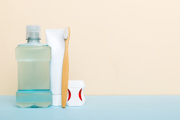 Mouthwash and other oral hygiene products on colored table top view with copy space. Flat lay. Dental hygiene. Oral care products and space for text on light background. concept