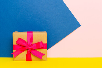 holiday paper present tied pink ribbon bow top view with copy space. Flat lay holiday background. Birthday or christmas present. Christmas gift box concept with copy space