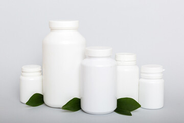 supplement pills with medicine bottle health care and medical top view. Vitamin tablets. Top view mockup bottle for pills and vitamins with green leaves, natural organic bio supplement, copy space