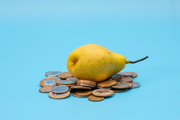 a pear on top of a pile of coins