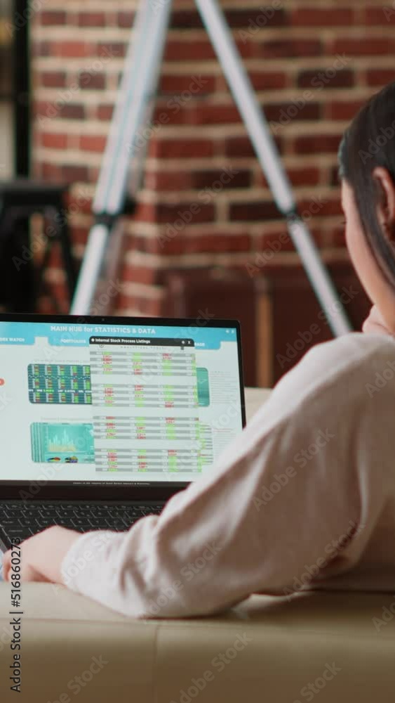 Poster vertical video: asian woman working from home while analyzing financial data report on laptop. perso