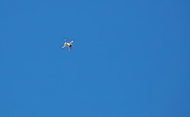 Drone flying in blue sky.