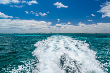 Trail of water left by a boat in the lake, travel image on a boat in Caribbean Ocean near Cancun,...