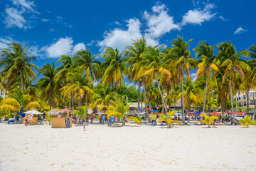 Obraz na płótnie Canvas Cocos beach bar on a beach with white sand and palms on a sunny day, Isla Mujeres island, Caribbean Sea, Cancun, Yucatan, Mexico