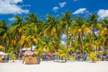 Obraz premium Cocos beach bar on a beach with white sand and palms on a sunny day, Isla Mujeres island, Caribbean Sea, Cancun, Yucatan, Mexico