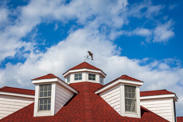 Red Roof, Dolphin Weather Vane and Clouds in the Sky - obrazy, fototapety, plakaty