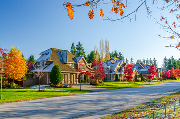Neighbourhood of luxury houses with street road, big trees and nice landscape in Vancouver, Canada. Blue sky. Day time on September 2021
