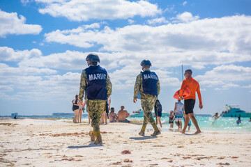 Militaries walking along the beach with machine guns, Isla Mujeres island, Caribbean Sea, Cancun, Yucatan, Mexico - obrazy, fototapety, plakaty