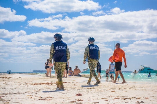 Militaries walking along the beach with machine guns, Isla Mujeres island, Caribbean Sea, Cancun, Yucatan, Mexico