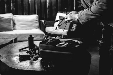 Hands of photographer preparing photo accessories, batteries and cables from his bag in a rustic...