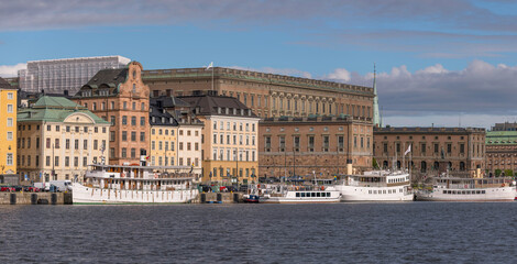 Old steam boats at the pier Skeppsbron in the old town Gamla Stan, a sunny summer day in Stockholm